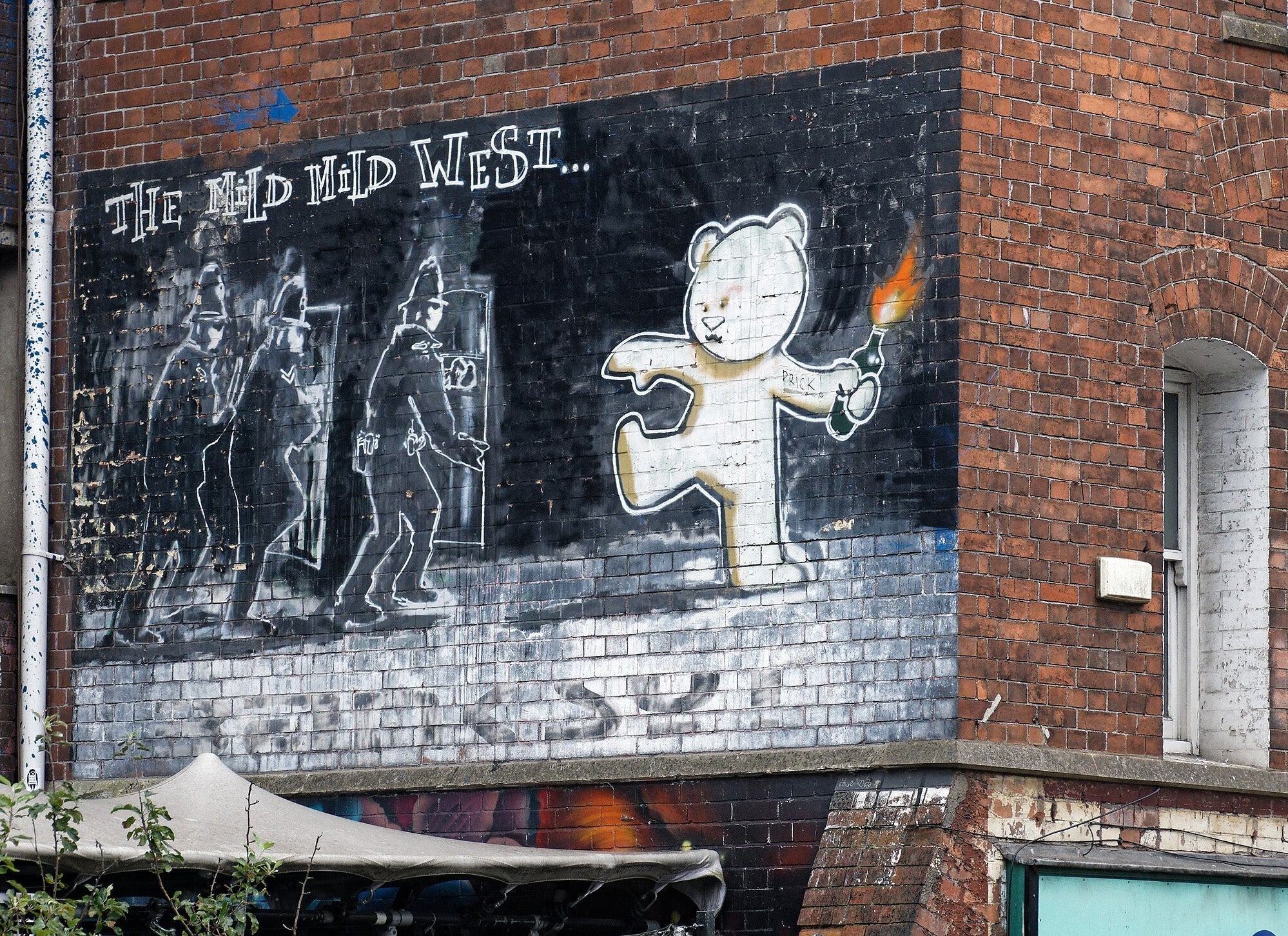 A banksy artwork on a brick wall